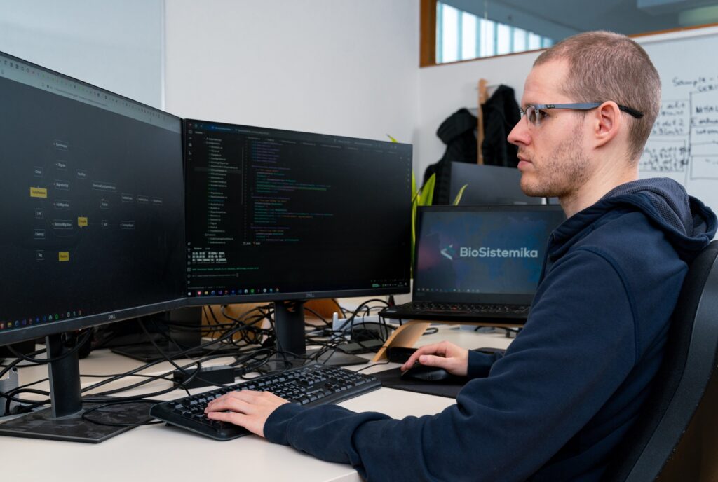 image of biosistemkia team working in laptop and led screen on biosistemika website