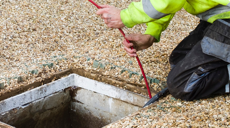 image of my plumber company employee cleaning manhole with long wire fixing drainage